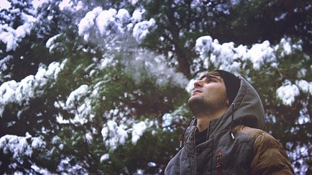 man feeling cold in the woods during snow