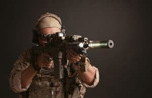 man in full gear aiming rifle using holographic sight