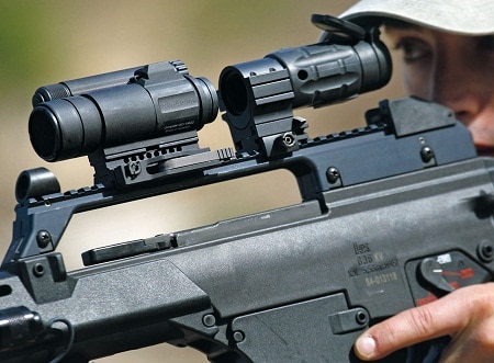 red dot sight and magnifier on rifle aimed by lady