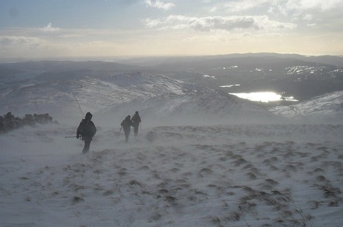 three hikers trekking the snowy peak 