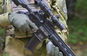 uniformed man holding airsoft rifle with sights