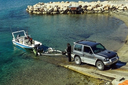boat on water pulled on trailer attached to suv