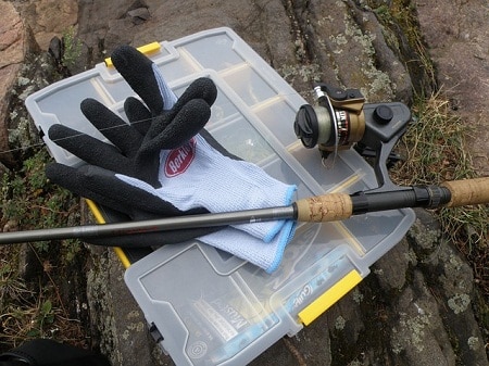 fishing rod and gloves on a tackle box