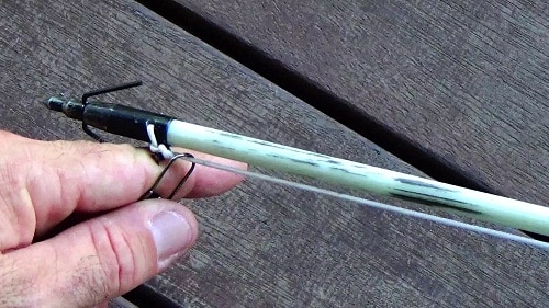 hand setting up arrow tip for bow fishing