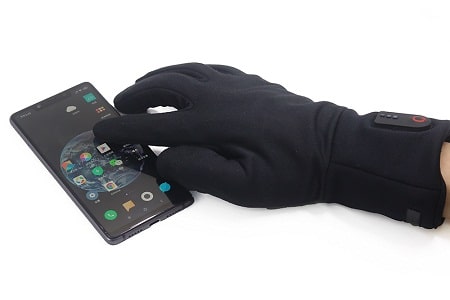 hand wearing heated glove navigating phone