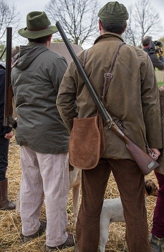 Hunters carrying rifles back view