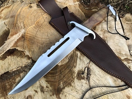 hunting knife with leather sheath on a wood trunk