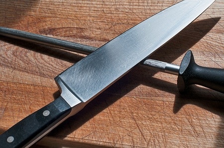 knife and sharpening steel on cutting board