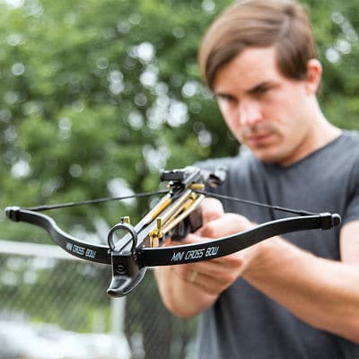 man aiming a crossbow pistol