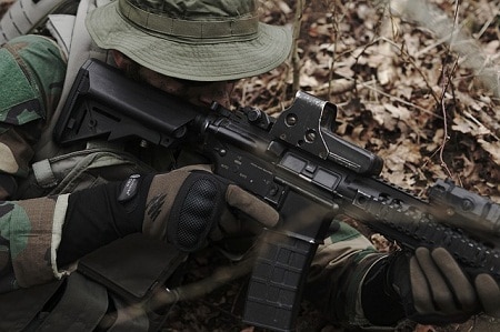 man in full gear aiming airsoft rifle
