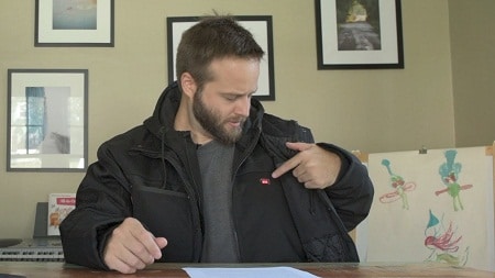 man wearing heated jacket pointing at inner layer