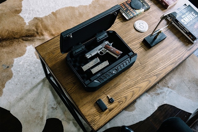 Vaultek VTi Portable Biometric handgun safe with pistols on wooden table