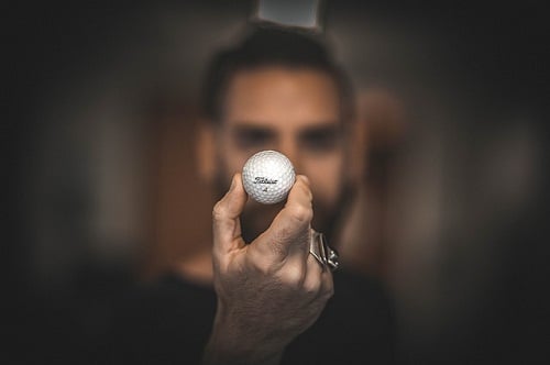 focused hand holding a golf ball