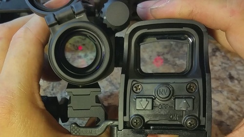 hand holding red dot and holographic sights