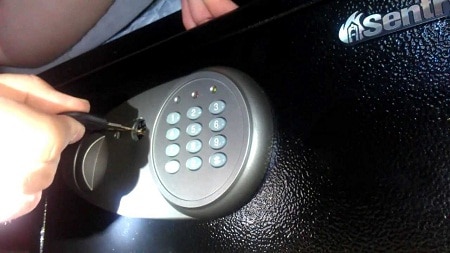 hand opening a gun safe with key