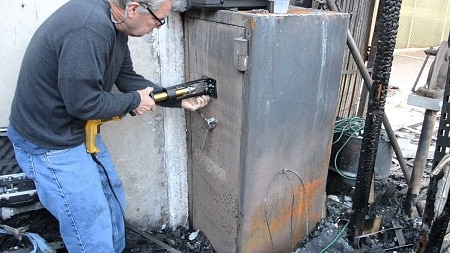 man opening a gun safe after fire incident