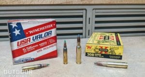 Box of 5.56mm ammo next to a box of .308 ammo with a few cartridges in front