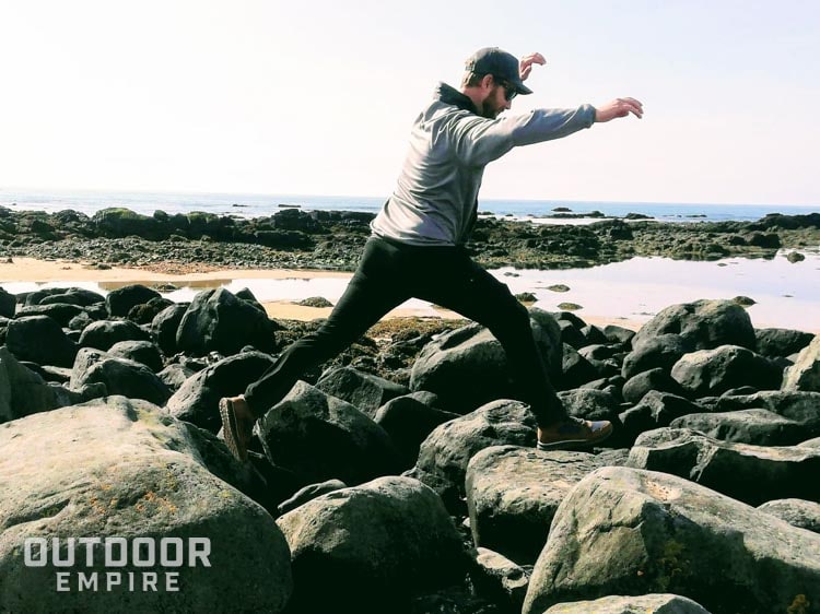 Man jumping from boulder to boulder on a beach in Iceland
