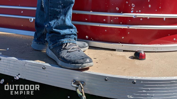 Water splashing on shoes on edge of boat deck