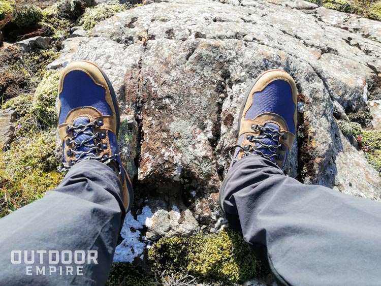 Looking down at Kodiak Skogan boots on feet on a rock
