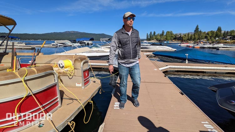 Man walking on a boat dock next to pontoon boat