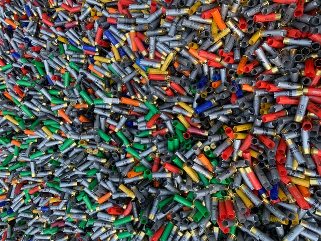 Pile of hundreds of empty shotgun shells of various colors