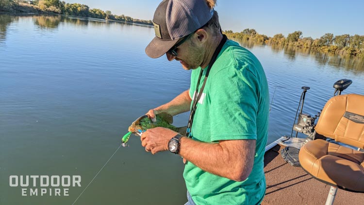 Man removing a lure from a smallmouth bass' mouth