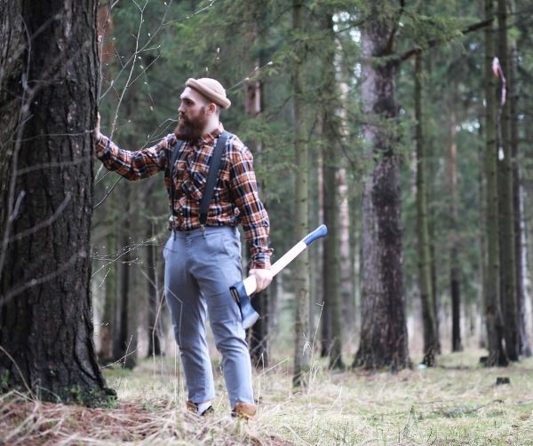 Lumberjack with a large axe holding tree trunk