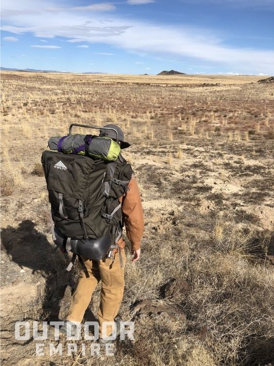 back view of a hiker with a Kelty Tioga pack on a grassland