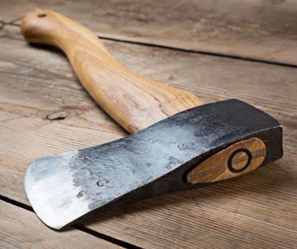 Wooden handle axe lying on wooden table