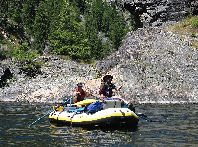 Man fly fishing from whitewater raft