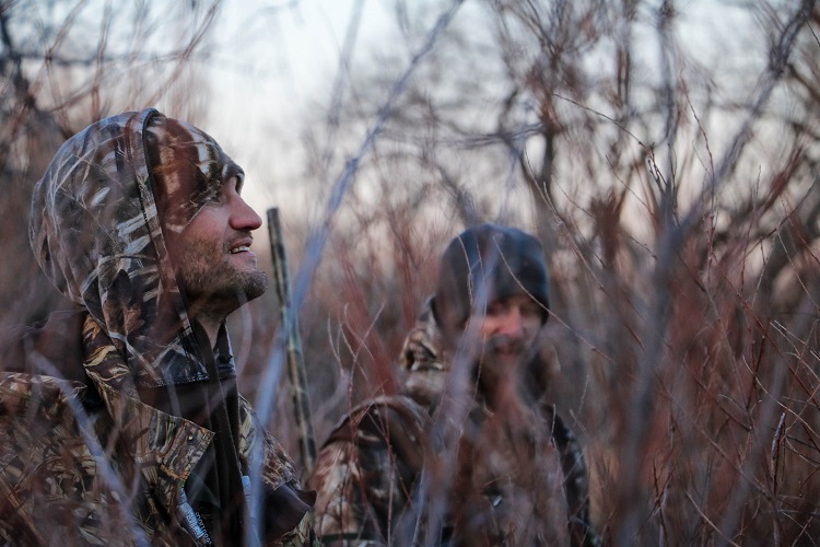 hunters camouflaged in the woods