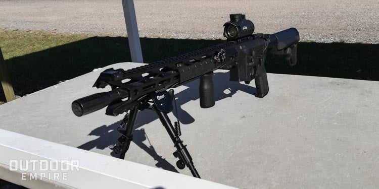AR-15 on table at range with red dot sight