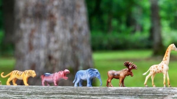 miniature toy animals against forest background