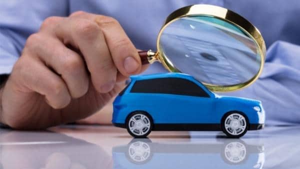 Person Holding Magnifying Glass Over Car