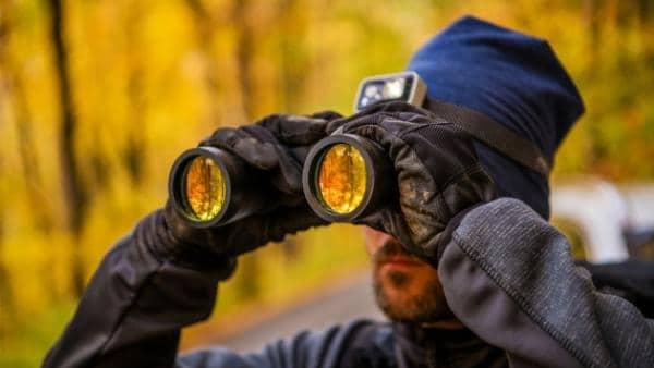 hiker looking into binoculars