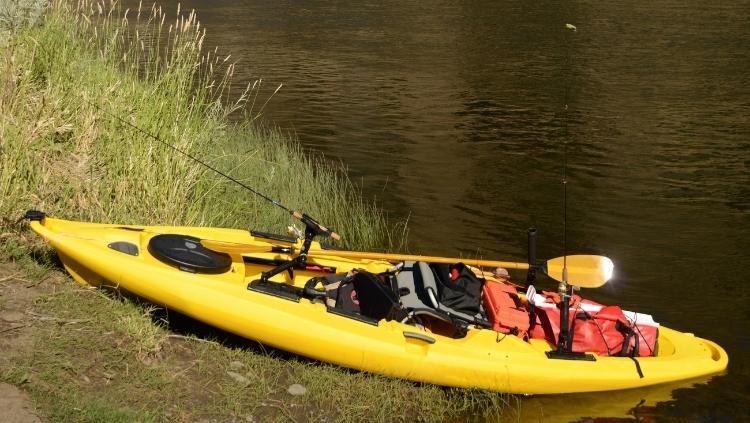 Loaded fishing kayak by the river