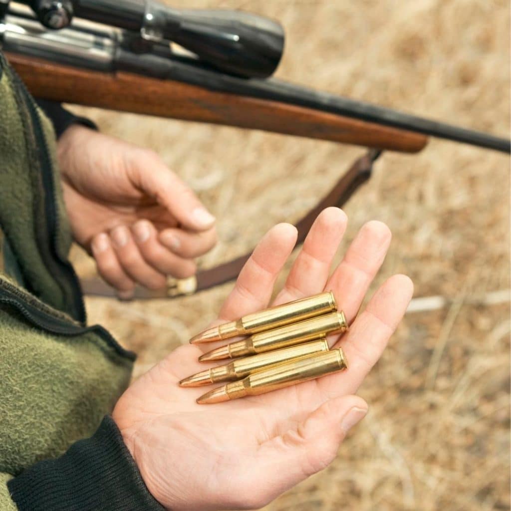 man holding hunting rifle and bullets