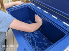 Woman cleaning a blue cooler