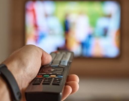 man holding remote in front of TV