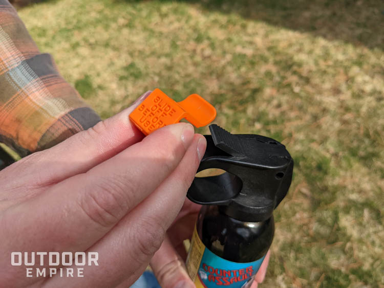 Removing safety clip from can of bear deterrent