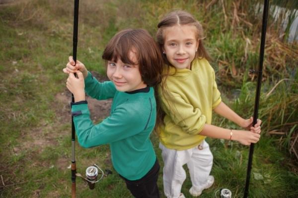 2 kids holding fishing rods
