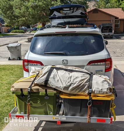 Canvas tent strapped on a hitch carrier on an suv