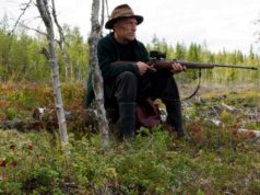 old hunter with rifle sitting