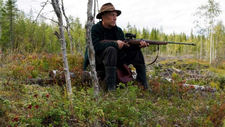 old hunter with rifle sitting