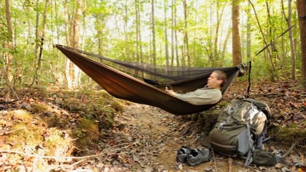 Man resting in camping hammock
