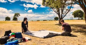 couple setting up tent on ground sheet