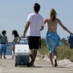 Family walking with cooler along boardwalk