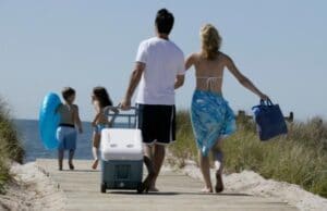 family walking with cooler along boardwalk