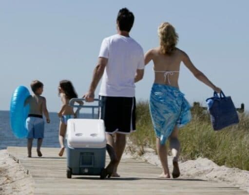 family walking with cooler along boardwalk